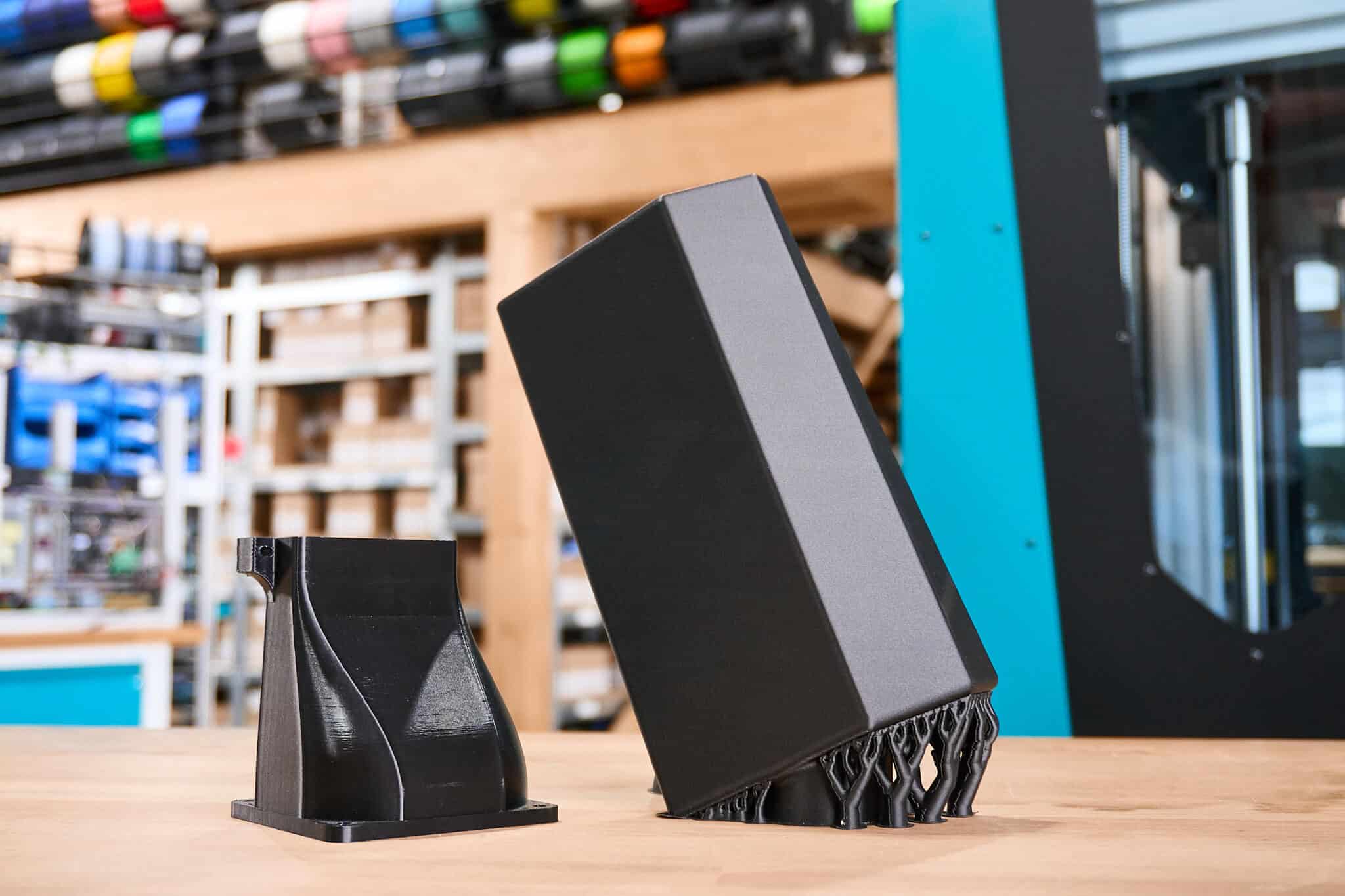 Vergleich zweier 3D-gedruckter Bauteile: links reguläres PLA, rechts PLA CF10 mit matter Carbon-Oberfläche